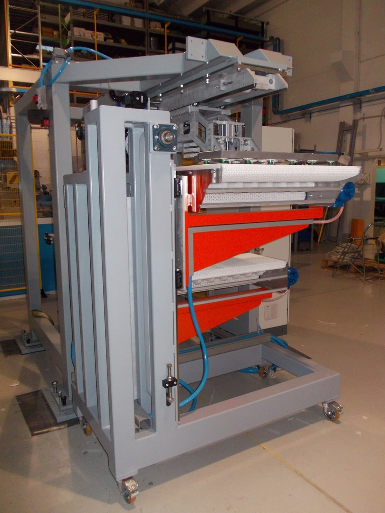 SISTEMA DI NASTRI IN ASSERVIMENTO A PICK AND PLACE CON MOVIMENTO VERTICALE A DISCESA STEP BY STEP PER FUNZIONE IMPILAMENTO